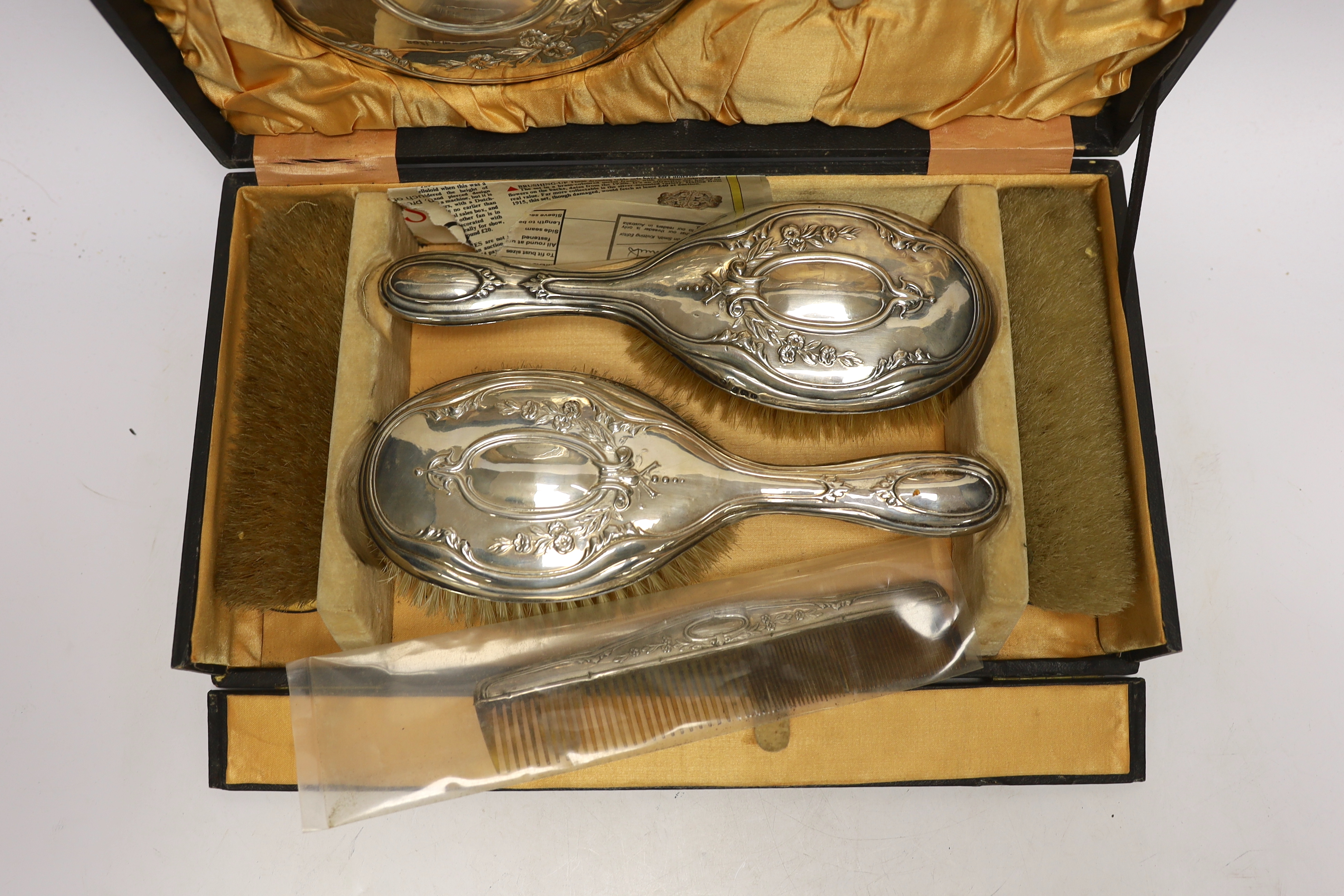 A cased silver four piece dressing table set.